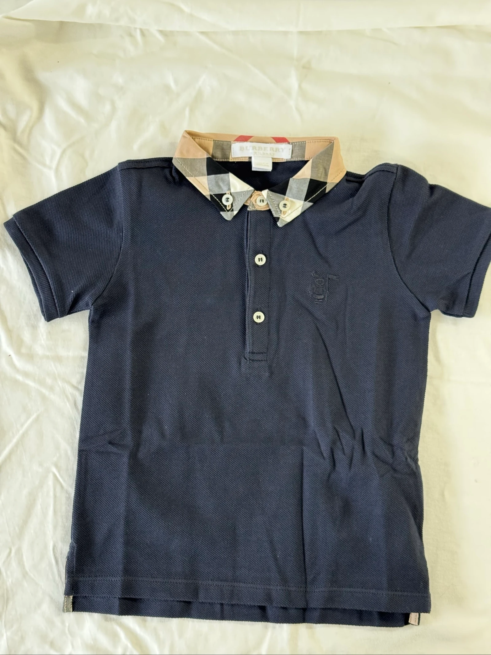 Polo pique azul marinho com gola em tecido xadrez